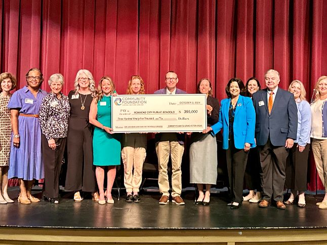  RCPS and Community Foundation Leaders stand together on a stage with a big check.